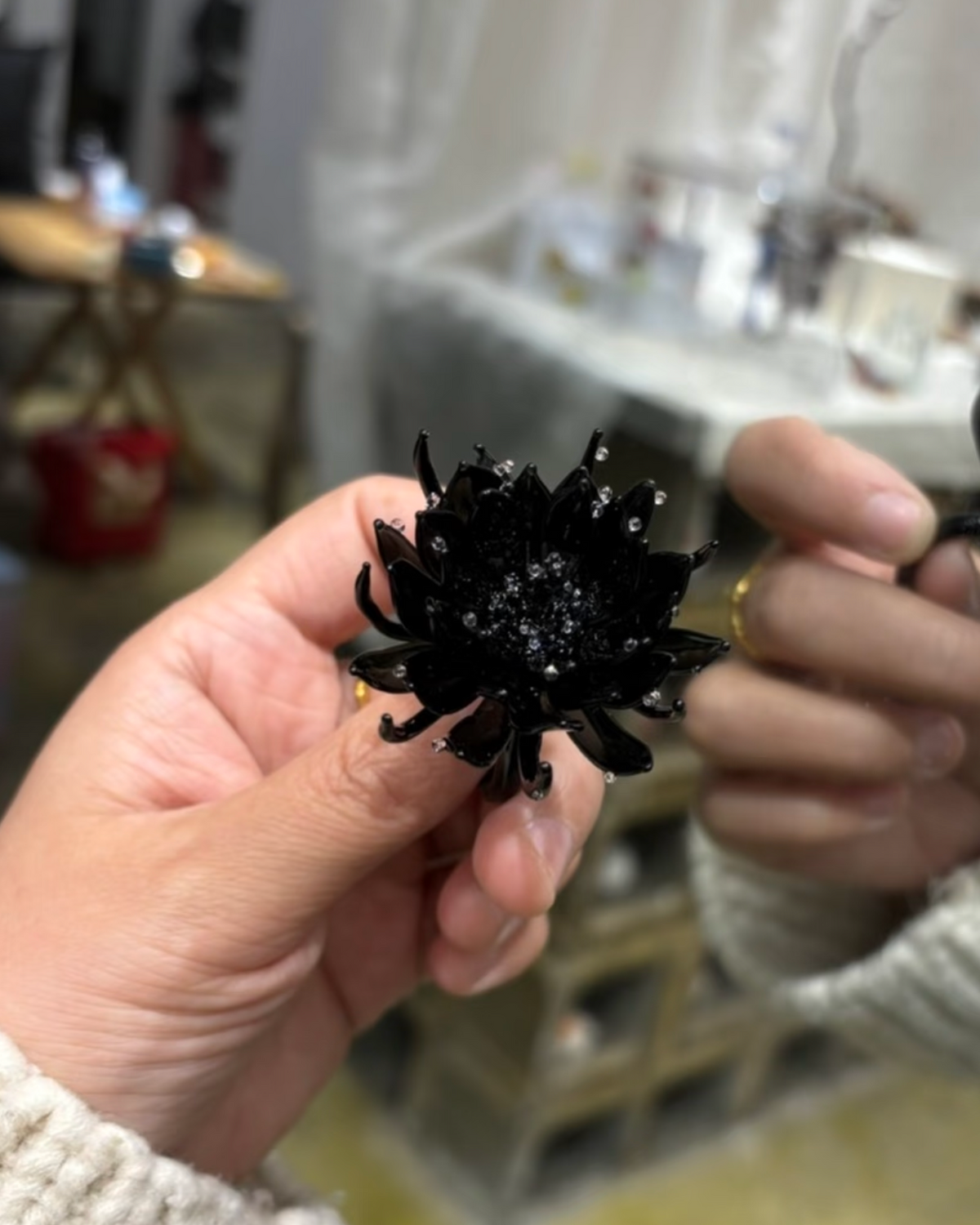 Hand holding black epiphyllum glass ring showing real size and details