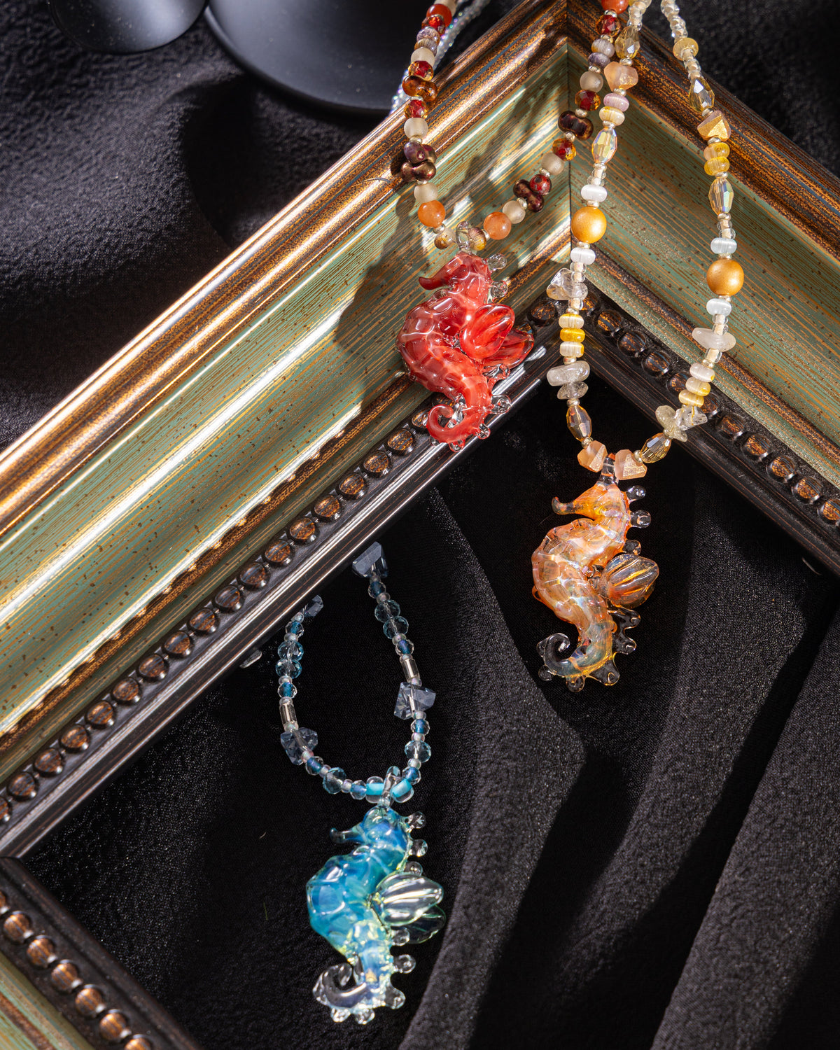 handmade lampwork glass seahorse pendant necklaces on wood background. Includes free titanium steel chain, beaded cord sold separately.