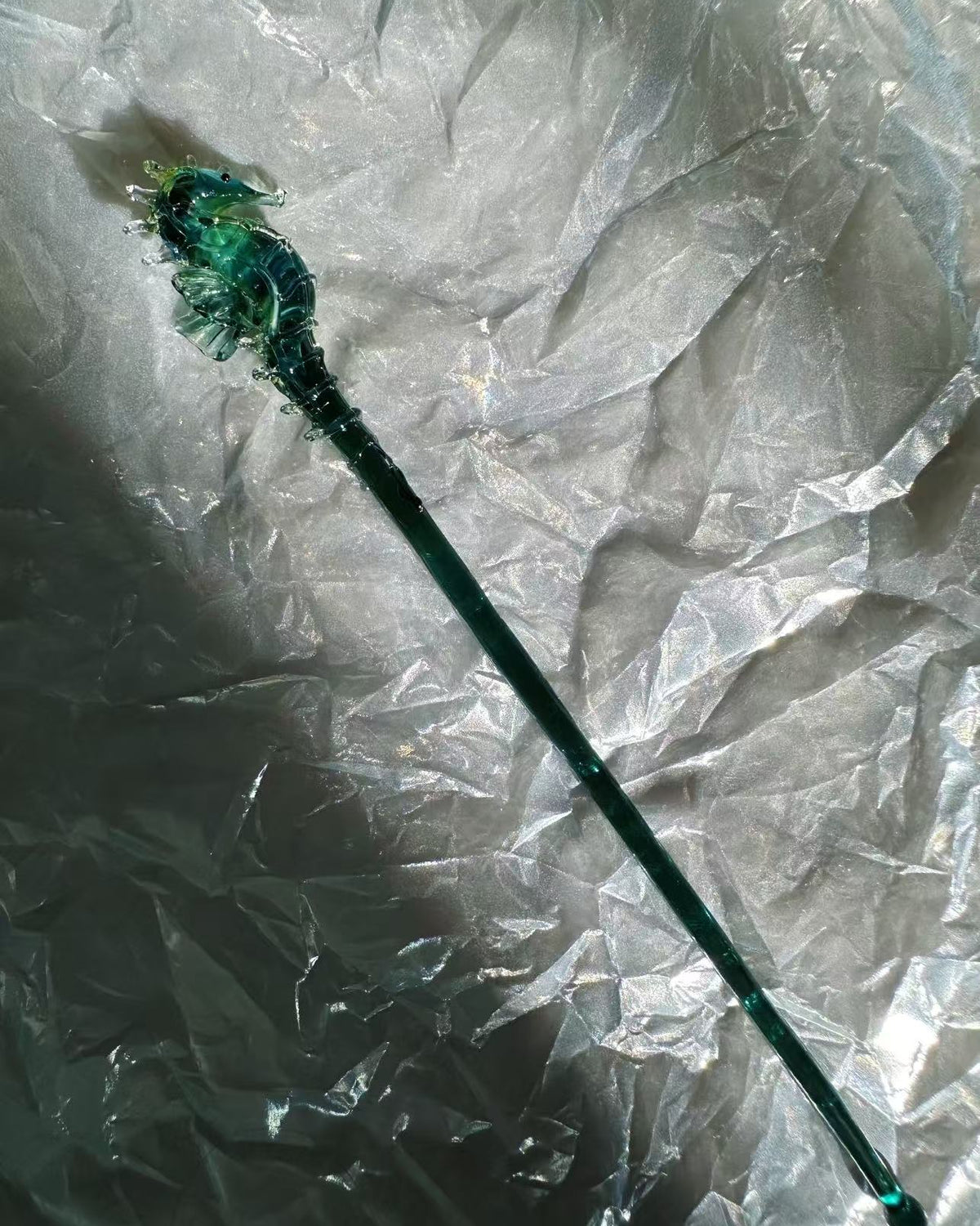  handmade lampwork glass seahorse drink stirrers, magical talisman barware, 18cm long, crossed display on dark background with botanical border.