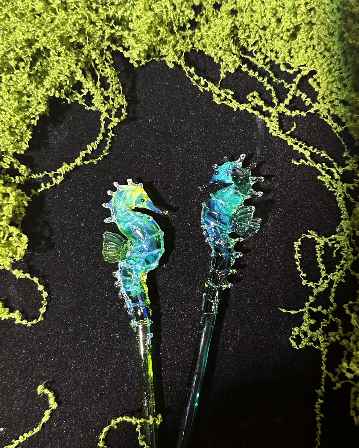  handmade lampwork glass seahorse drink stirrers, magical talisman barware, 18cm long, crossed display on dark background with botanical border.