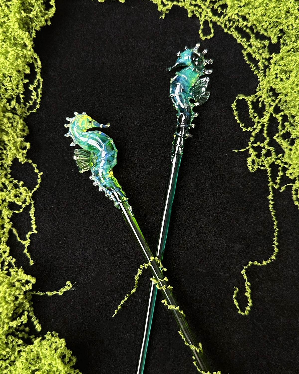  handmade lampwork glass seahorse drink stirrers, magical talisman barware, 18cm long, crossed display on dark background with botanical border.