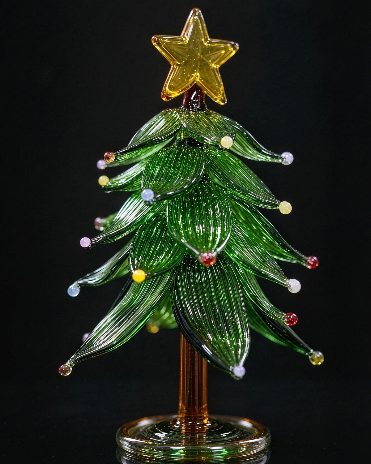 Handmade lampwork glass Christmas tree with star topper and colored dots, miniature tabletop holiday decor with clear base, black background product photography.
