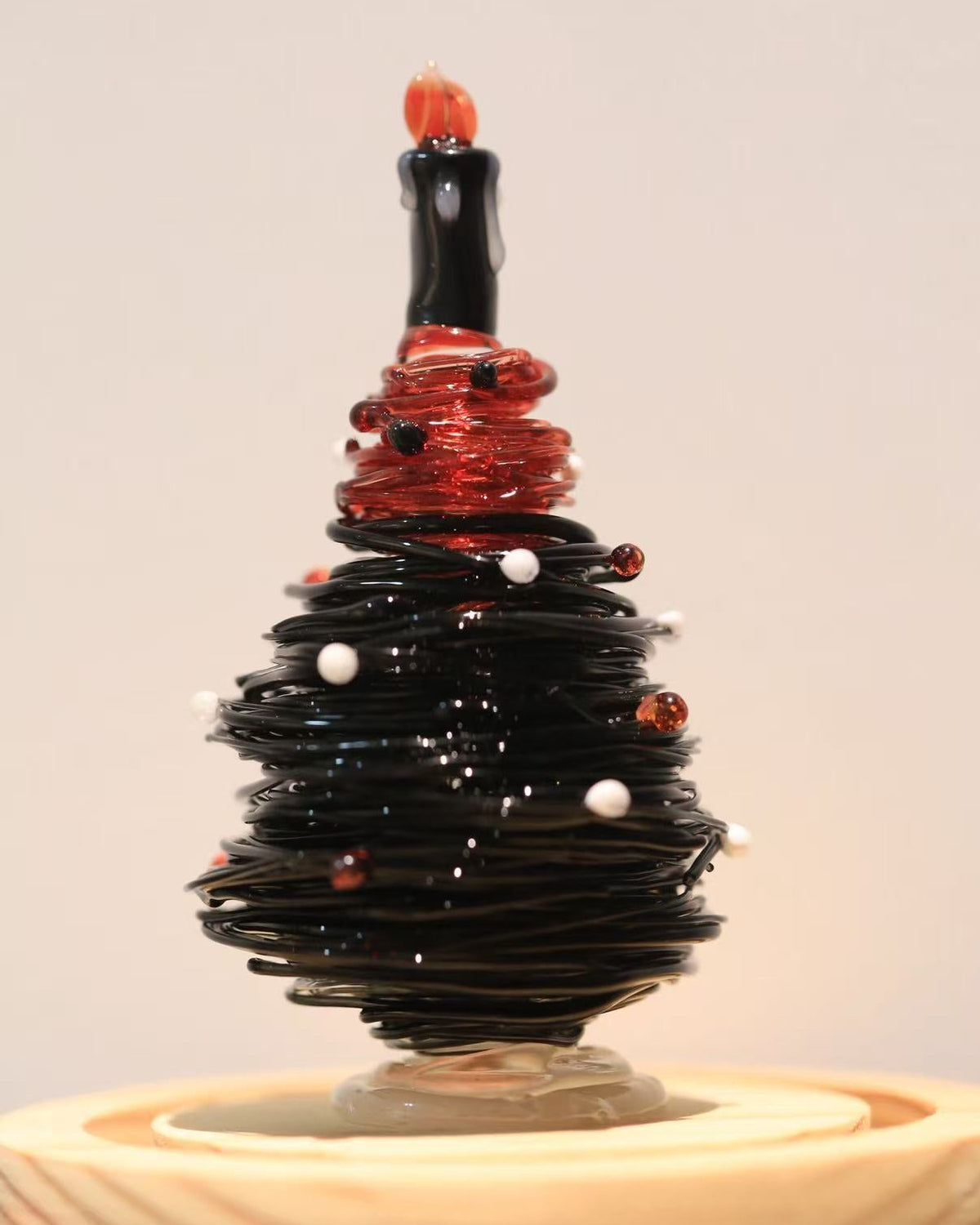 Black and red gradient glass Christmas tree with candle topper and wooden base